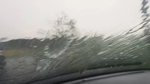 View from inside vehicle as hail sleet and rain hit the windshield during storm. Stock Footage 295774555