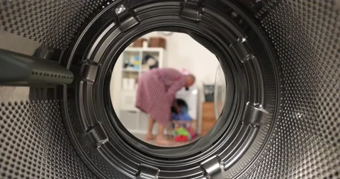 View from inside a washing machine, a man puts a colored wash into the washing Stock-Footage 178559093