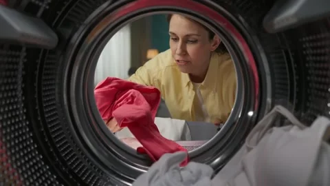 View from inside the washing machine, young couple having a little fight because Stock Footage 247467351