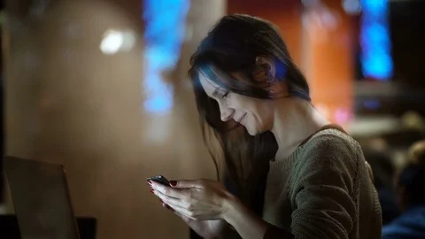 View inside the window on beautiful female using the smartphone. Woman sitting Stock Footage