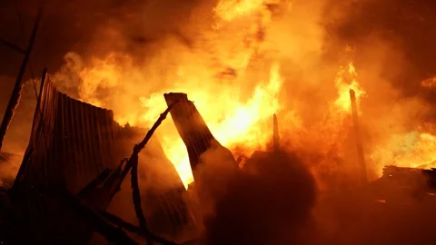 View of intense fire engulfing structures at night, Bangladesh. Video stock 335562236