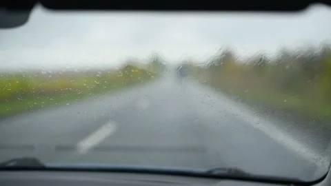 View from the interior of the car on  windshield in rainy autumn weather.Wipers Stock Footage 217788974