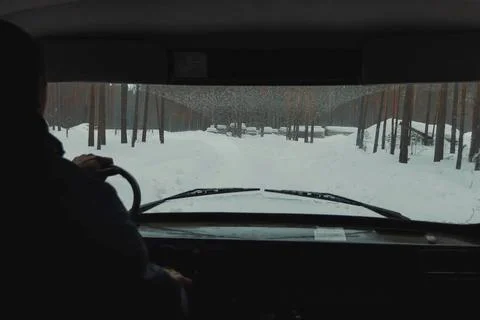 View from the interior of car into the windshield, winter road through the .. Stock Photos