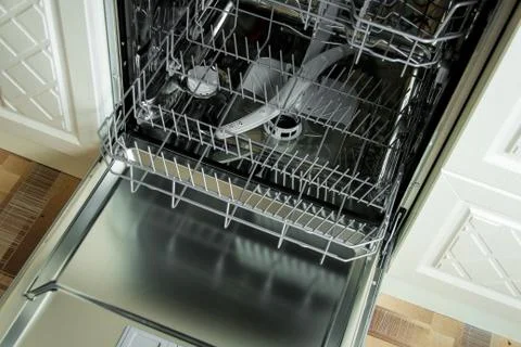 View of the interior of an empty opened dishwasher. Stock Photos