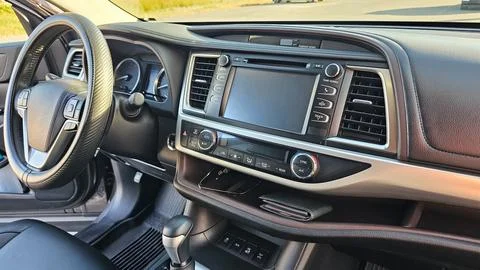A view of the interior of a modern SUV car, with the dashboard, console, stee Stock Photos