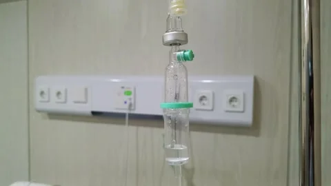 View of an intravenous drip chamber connected to an infusion fluid bag Stock Footage 316897014