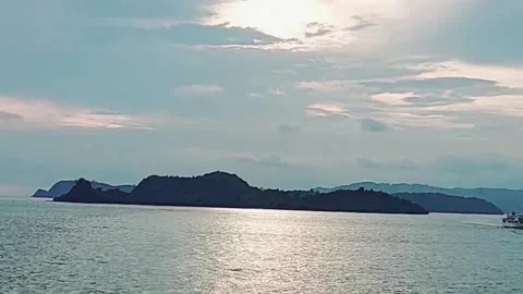 View of an island and a ship in the distant sea in the morning Stock Footage 241162053