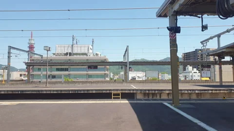 View from Japan train window. Taking off slowly from station Stock Footage 245372716