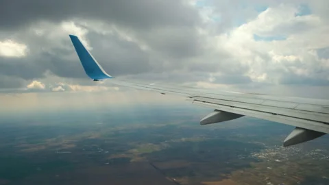 View of jet airplane wing shaking from air turbulence while flying through dark Stock Footage 229724091