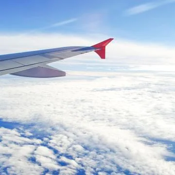 View of jet plane wing with cloud patterns Stock Photos
