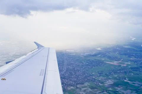 View of jet plane wing with cloud patterns Stock Photos