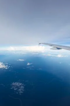 View of jet plane wing with clouds over the Amazonas State, Colombia Stock Photos