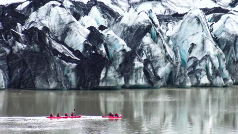 View of kayaks sailing next to the impressive front of Skaftafell glacier. Stock Footage 251832714