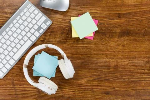 View of a keyword with headphones and small colorful sheets of paper on wood Stock Photos