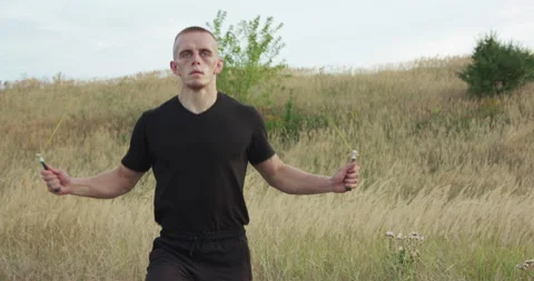 View of kickboxer doing jumps on skipping rope on nature 스톡 동영상 132634525