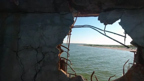 View of the Kinburn Spit through a hole in the side of an old abandoned bar.. Stock Footage 274729760