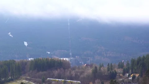 View of Krkonose mountains with moving clouds, commuter train moving in Szk.. Stock Footage 328406757
