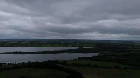 A view of a lake and countryside with clouds in the sky Stock Footage 328536333