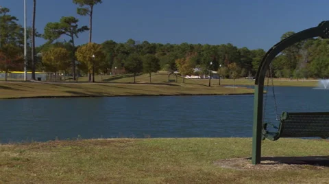 View of lake and swing bench in park Stock Footage 57815495