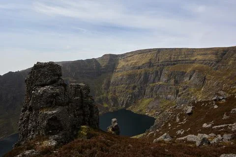 View of a lake between large rocks of a mountainous valley. Comeragh Mountain Stock Photos