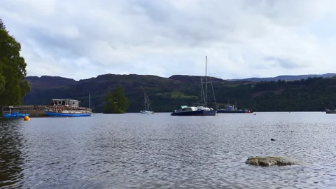 A view of a lake with boats surrounded by mountains. Stock Footage 127546244