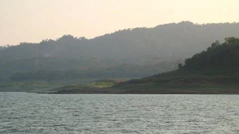 View of the lake with a hill in the background in the afternoon Video stock 280690127