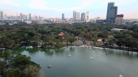 View of Lake Inside of a Park, and Bangkok City's Skyline in the Horizon. Aerial Stock-Footage 123715009