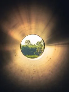 A view of the lake in spring, seen through the pipe. Stock Photos
