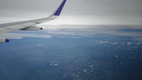 View of landscape while airplane moving through clouds, FullHD 1080p Stock Footage 138681132