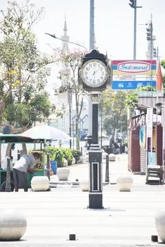 View of a large ancient clock in the middle of the street sidewalk Stock Photos