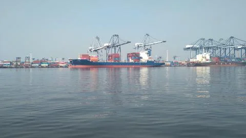 View of large container cargo vessels being loaded and unloaded by large cranes Stock Photos
