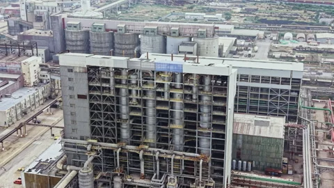 View of a large industrial complex with tall chimneys and pipes under clear sky Stock Footage 341586282