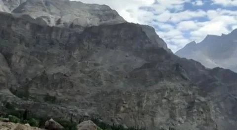 A view of a large mountain range with a few trees Stock Footage 318505667