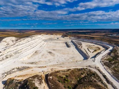 View of a large quarry with multiple levels showcasing white rock extractio.. Stock Photos