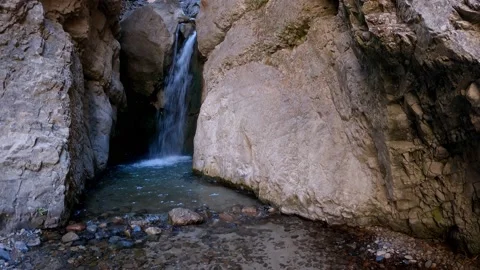 View of large rocks and a waterfall flowing between them Stock Footage 171534037