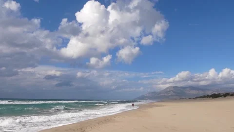 View Of A Large Sandy Sea Beach And A Young Woman In The Distance Stock Footage 195992364