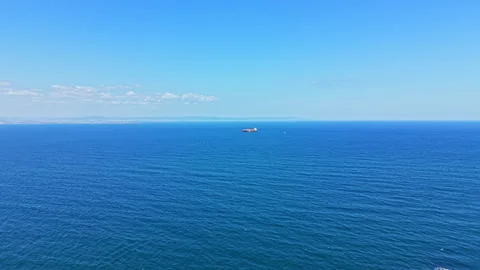 View of a large ship sailing on the ocean under a clear blue sky with calm water Stock Footage 344790539