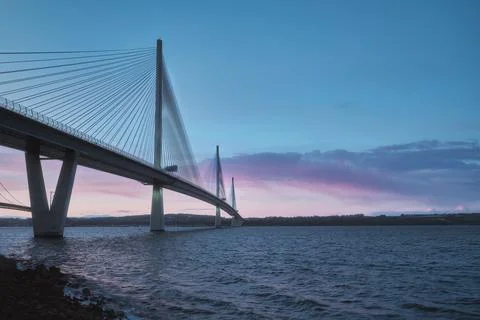 A view of a large three-tower cable-stayed bridge at sunrise Stock Photos
