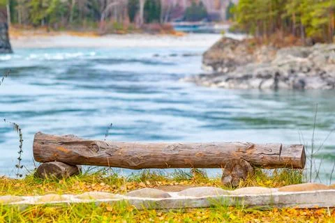 View of a large untreated tree log in the form of a bench Stock Photos