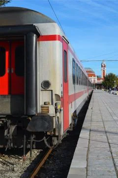 View from the last white passenger train car to the railway station Stock Photos