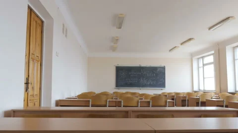 View of lecture hall. Large blackboard, rows of wooden desks and chairs Stock Footage 91898437