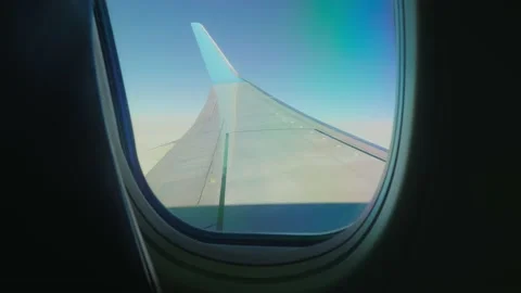 View of left wing of plane framed by the plane window. View from passenger Stock Footage 145830091