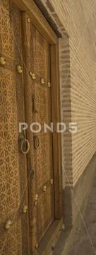 View from leftside of old ornate wooden door with beautiful carvings in Bukha Stock Photos