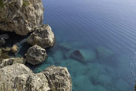 View of the light limestone rock and boulders in the blue water Stock Photos
