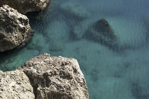 View of the light limestone rock and boulders in the blue water Stock Photos