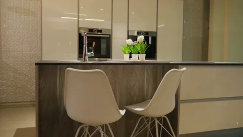 View of light stylish kitchen in the modern style with white wooden table with Stock Footage 77050496