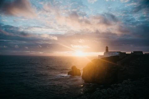 View of the lighthouse and cliffs at Cape St. Vincent in Portugal at sunset. Stock Photos