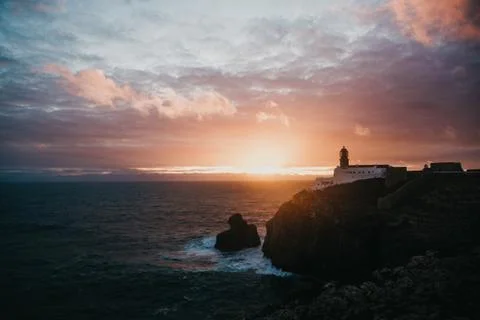 View of the lighthouse and cliffs at Cape St. Vincent in Portugal at sunset. Stock Photos