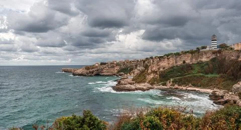 View of lighthouse at seashore against cloudy sky. Beautiful Lighthouse On Th Stock Photos