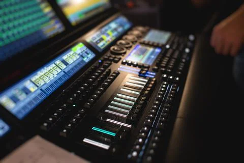 View of lighting technician operator working on mixing console workplace duri Stock Photos